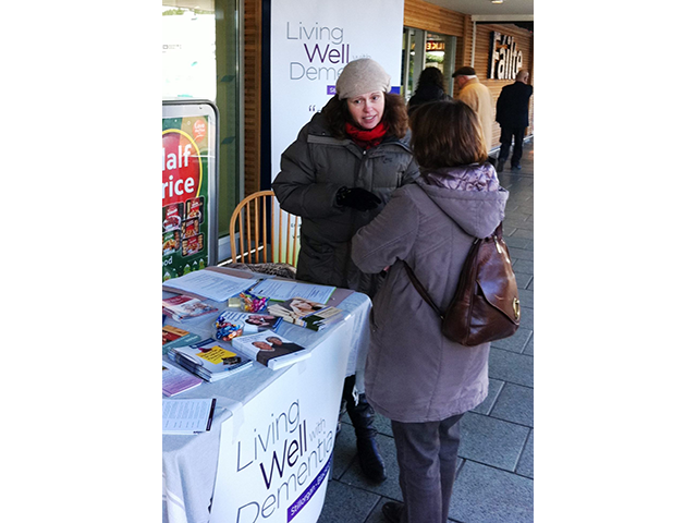 A project member chats to a local shopper to raise awareness about dementia